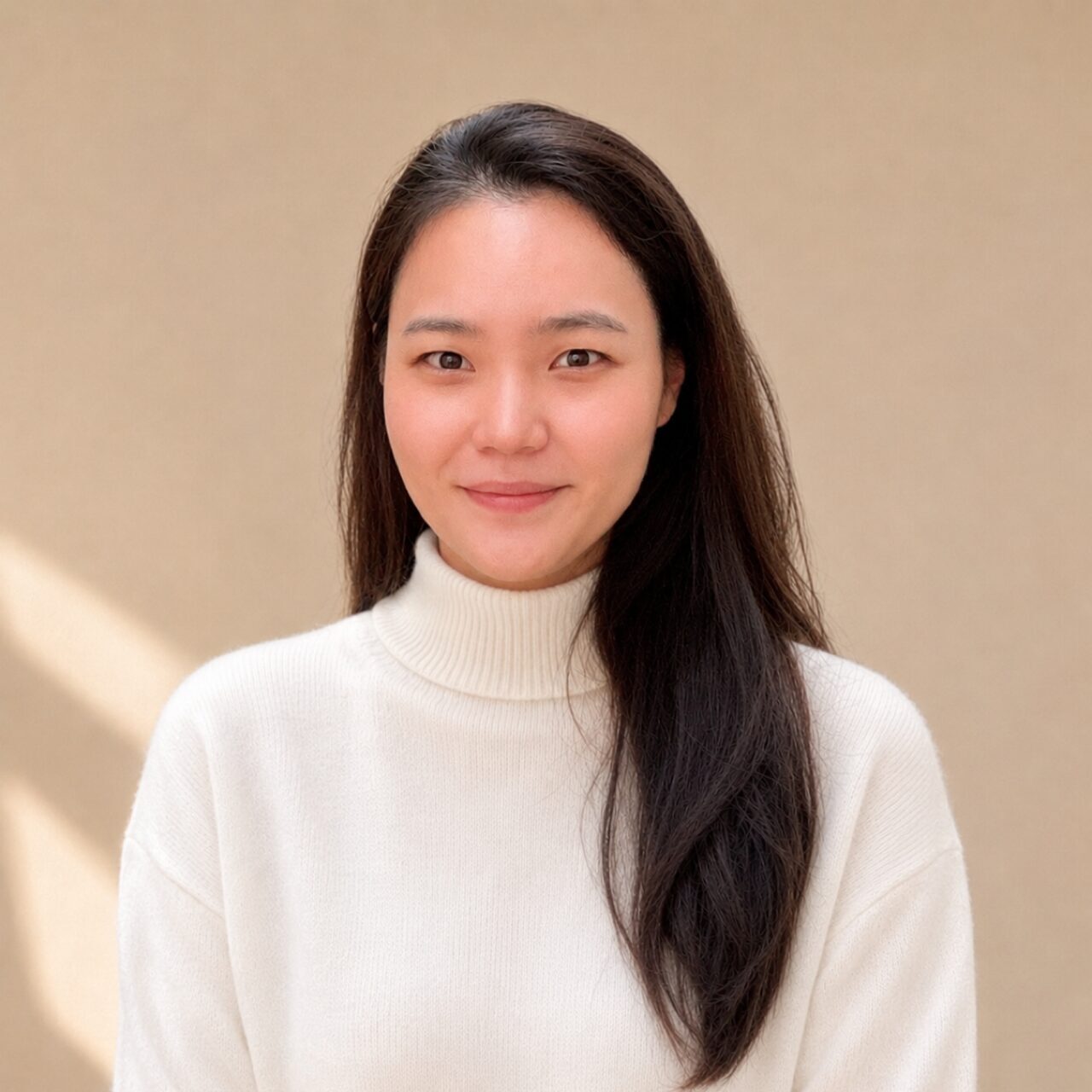 A headshot photo of Minji Ju, Administrative Assistant at Granville Island Speech. She stands in front of a cream background.